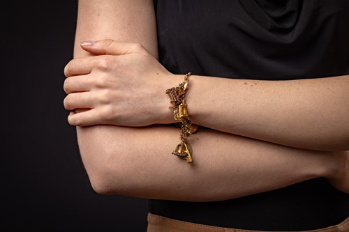 Lot 111 - A charm bracelet, the fancy bar and link...