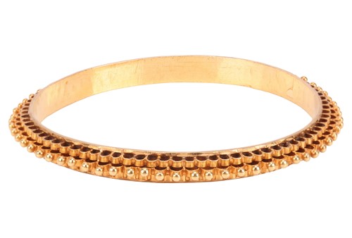 Lot 222 - A closed bangle, decorated with tiered fluting...