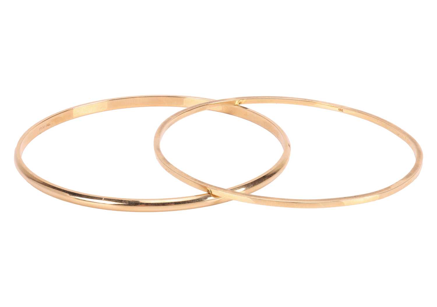 Lot Two closed bangles, the first composed of a...