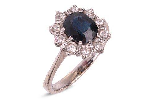 Lot 203 - A sapphire and diamond halo ring, centred with...