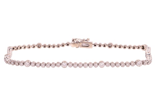 Lot 122 - A diamond line bracelet in 18ct white gold, by...