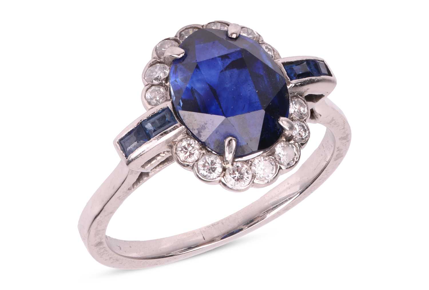 Lot 46 - A sapphire and diamond cluster ring; the oval...