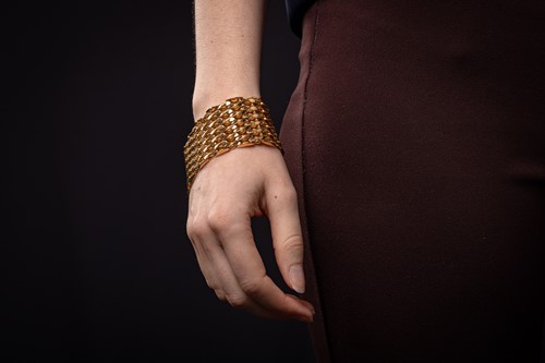 Lot 294 - A wide fancy link bracelet, comprising a...