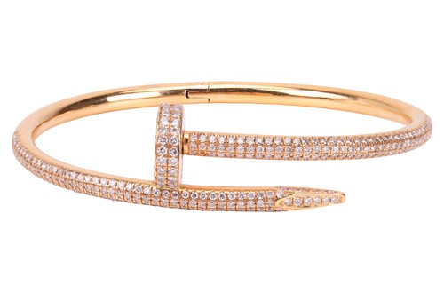 Lot 119 - A hinged bangle in the form of a nail, pavé...
