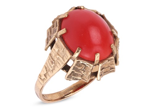 Lot 81 - A coral cabochon dress ring, set to the middle...