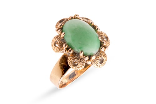 Lot 73 - A jadeite ring, the oval jadeite cabochon...