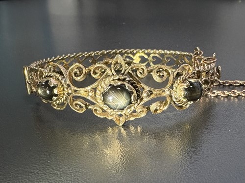 Lot 33 - A hinged bracelet set with black star...