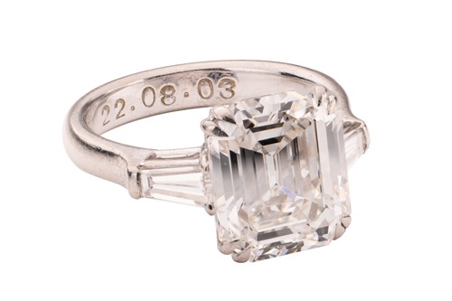 Lot An emerald-cut diamond solitaire ring, the...