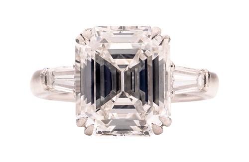 Lot An emerald-cut diamond solitaire ring, the...