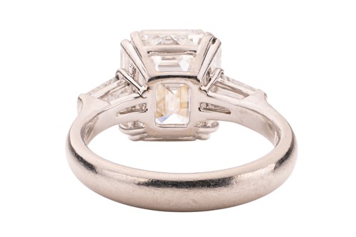Lot An emerald-cut diamond solitaire ring, the...