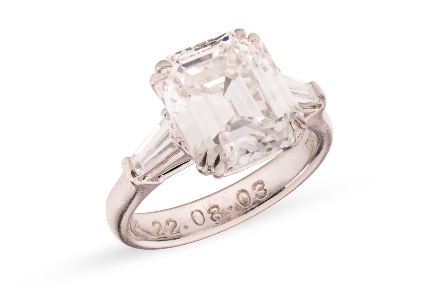Lot An emerald-cut diamond solitaire ring, the...