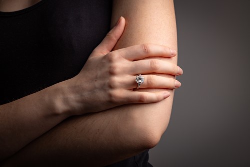 Lot An emerald-cut diamond solitaire ring, the...