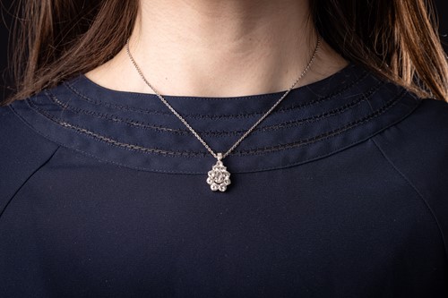 Lot 295 - A diamond cluster pendant on chain, with an...