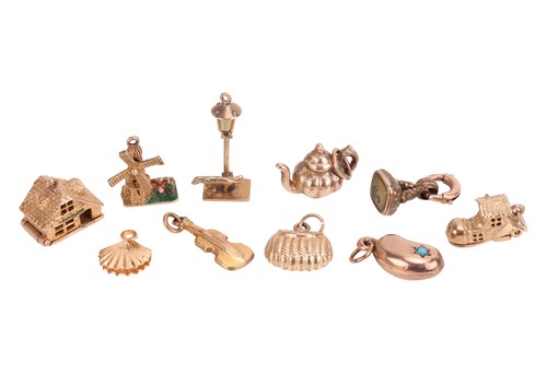 Lot 123 - A group of yellow metal charms, to include a...