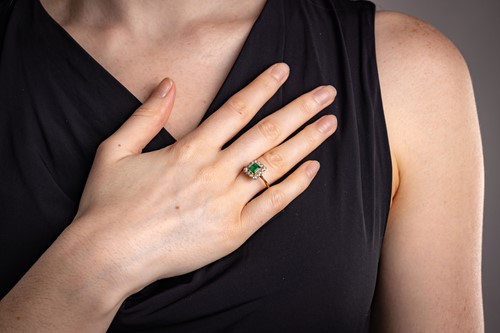 Lot 19 - An emerald and diamond cluster ring,...