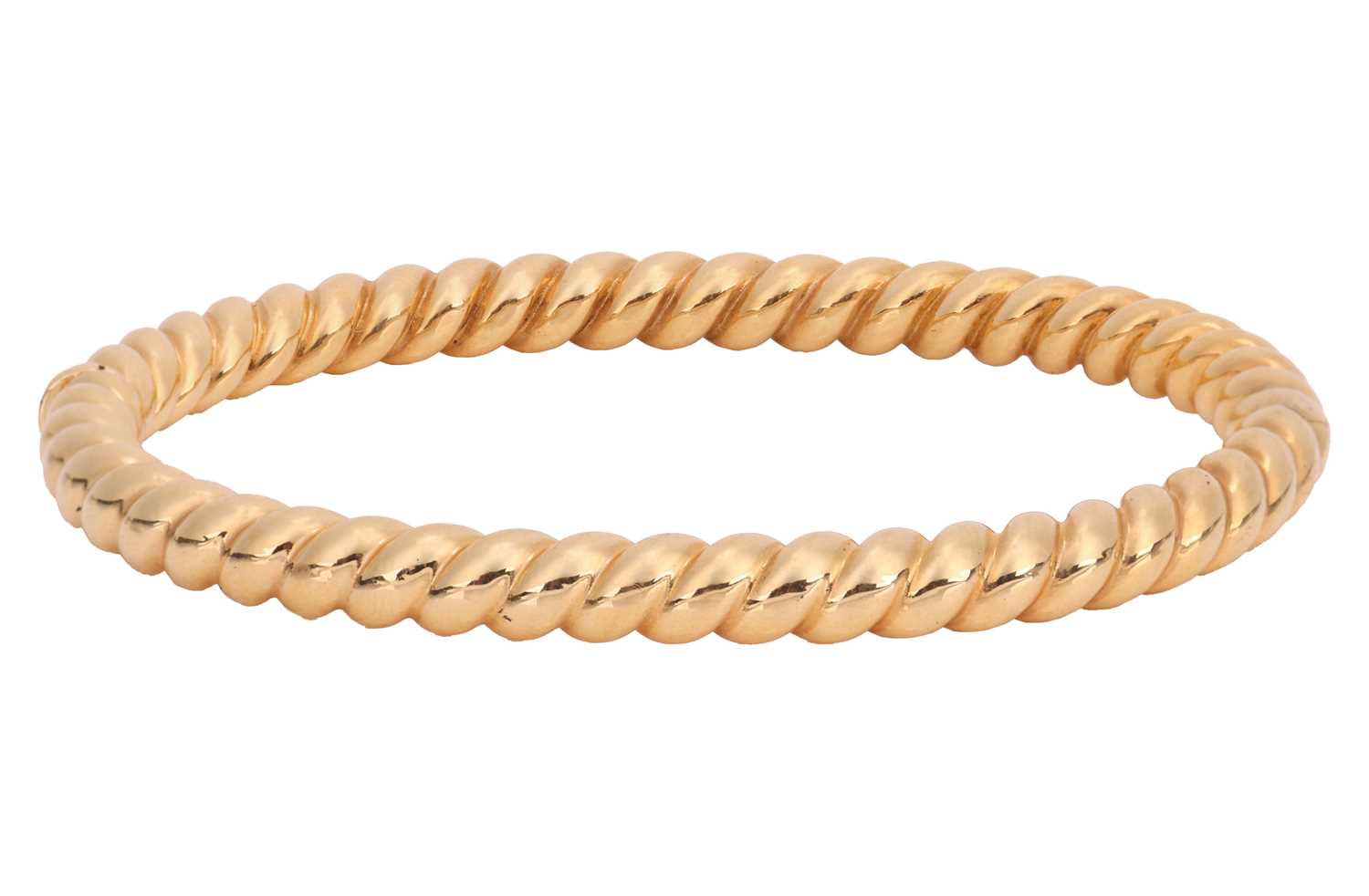 Lot 114 - A hinged bangle in 18ct gold, of twisted