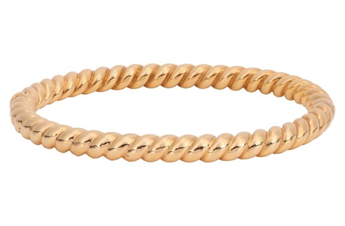 Lot 114 - A hinged bangle in 18ct gold, of twisted rope...
