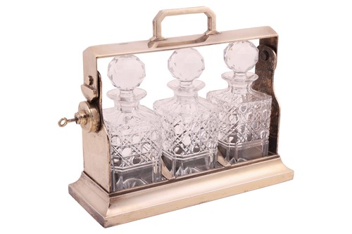Lot 72 - A silver plated three bottle tantalus; of...