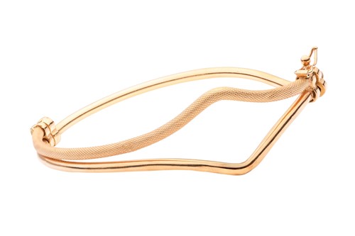 Lot 152 - A curved hinged bangle, with bifurcated design...