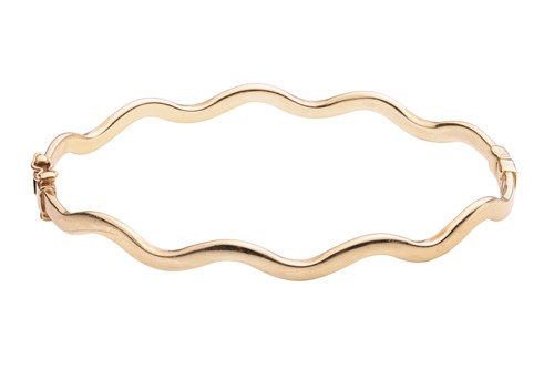 Lot 12 - A hinged oval bangle of undulating design,...