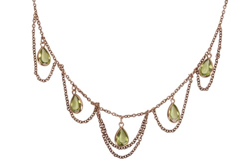 Lot 42 - A festoon necklace set with peridot drops, the...