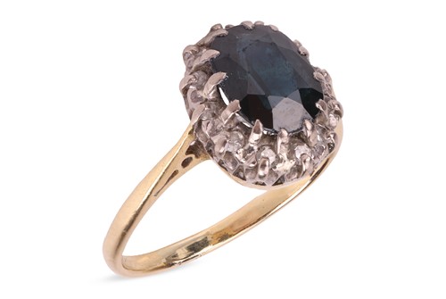 Lot 117 - A sapphire and diamond halo ring, centred with...