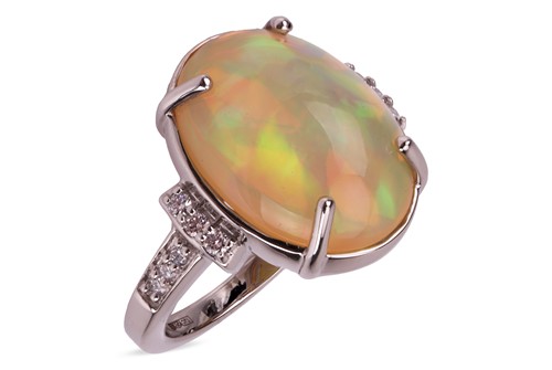 Lot 217 - An opal and diamond ring in platinum, the oval...