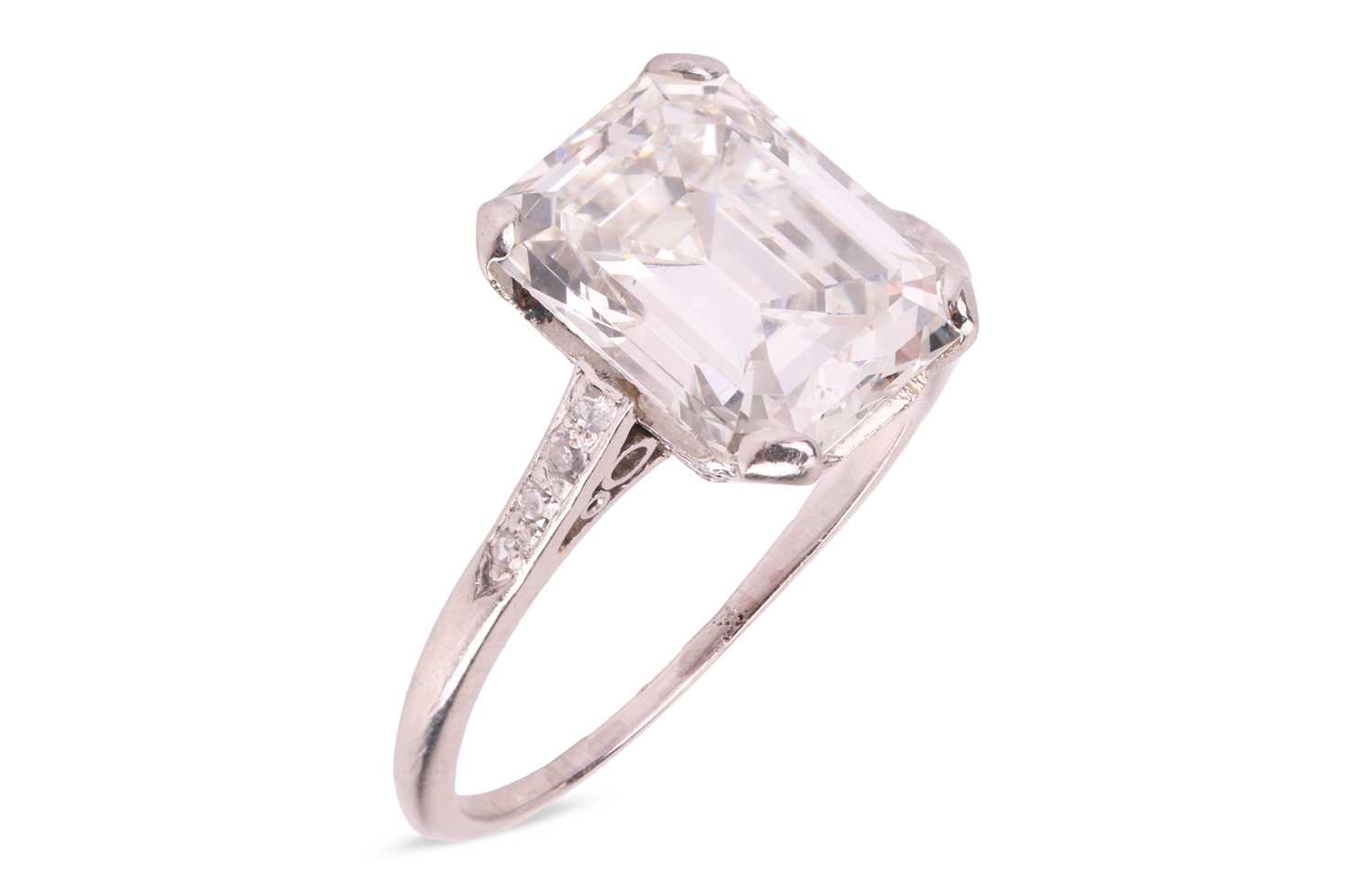 Lot An emerald-cut diamond solitaire ring, the...