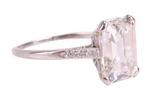 Lot An emerald-cut diamond solitaire ring, the...