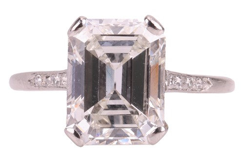 Lot An emerald-cut diamond solitaire ring, the...