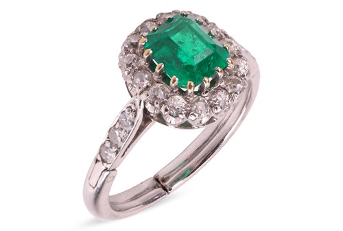 Lot 51 - An emerald and diamond halo ring, the step-cut...