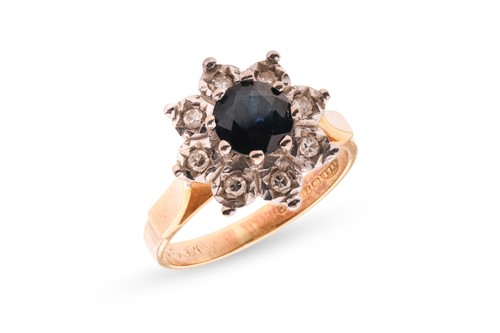 Lot 4 - A diamond and sapphire cluster ring, featuring...