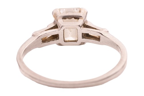 Lot An emerald-cut diamond solitaire ring,...