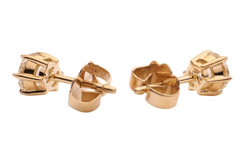 Lot A pair of diamond stud earrings, with a total...