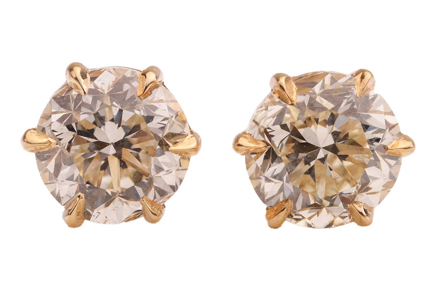 Lot A pair of diamond stud earrings, with a total...