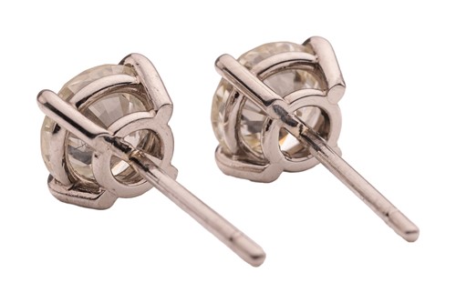Lot A pair of diamond stud earrings, with a total...