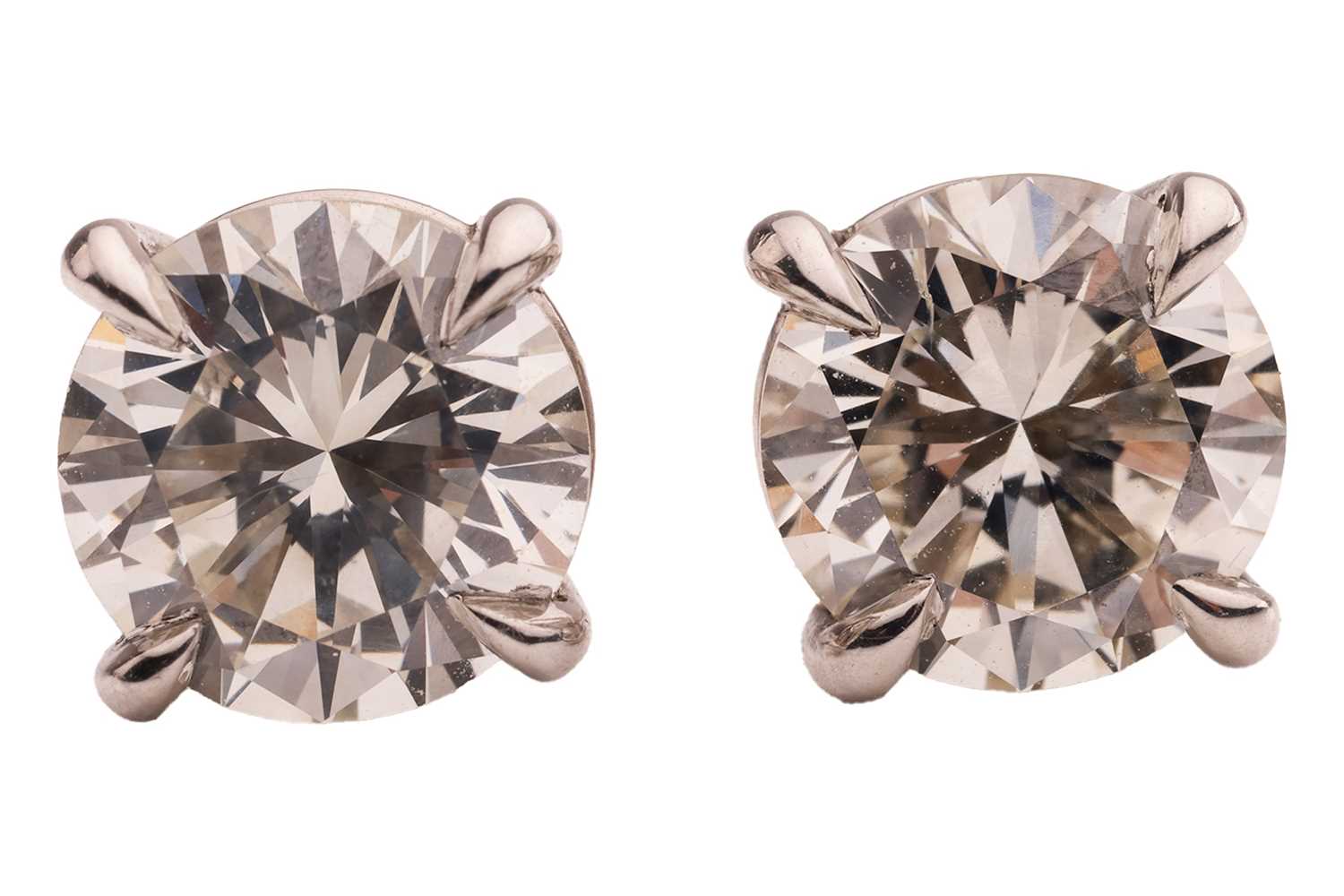 Lot A pair of diamond stud earrings, with a total...