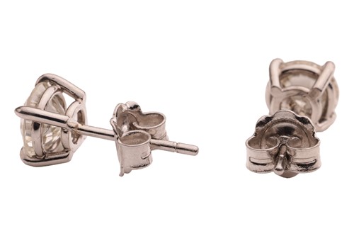 Lot A pair of diamond stud earrings, with a total...