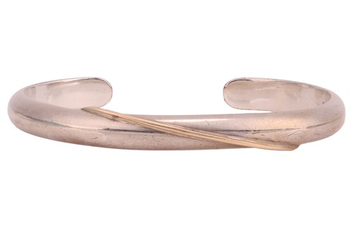 Lot 84 - A silver open cuff bangle, with a swirl detail,...