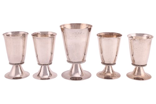 Lot 409 - A group of five hammered silver goblets of...