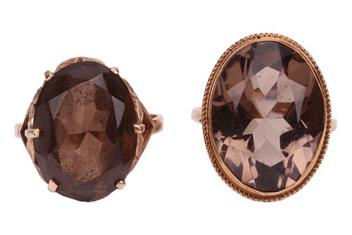 Lot 15 - Two smoky quartz rings; both set with oval-cut...