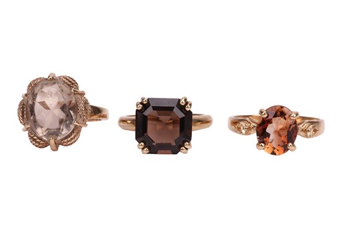 Lot 61 - Two smoky quartz dress rings, and a brown...
