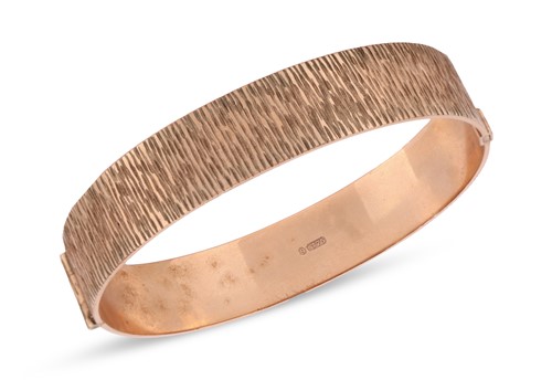 Lot 82 - A 9ct yellow gold hinged bangle, of bark...