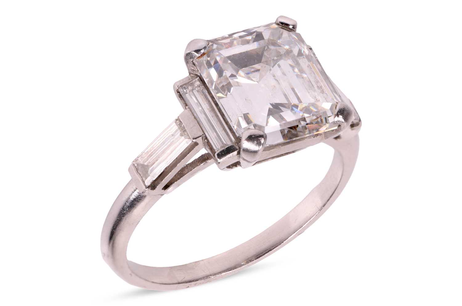 Lot An emerald-cut diamond dress ring, featuring...