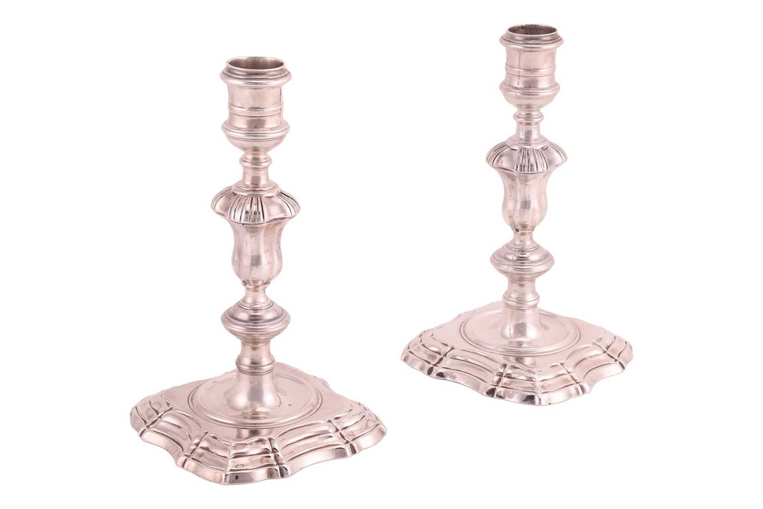 Lot A pair of George II silver cast candlesticks,...