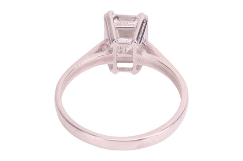 Lot An emerald-cut diamond solitaire ring,...
