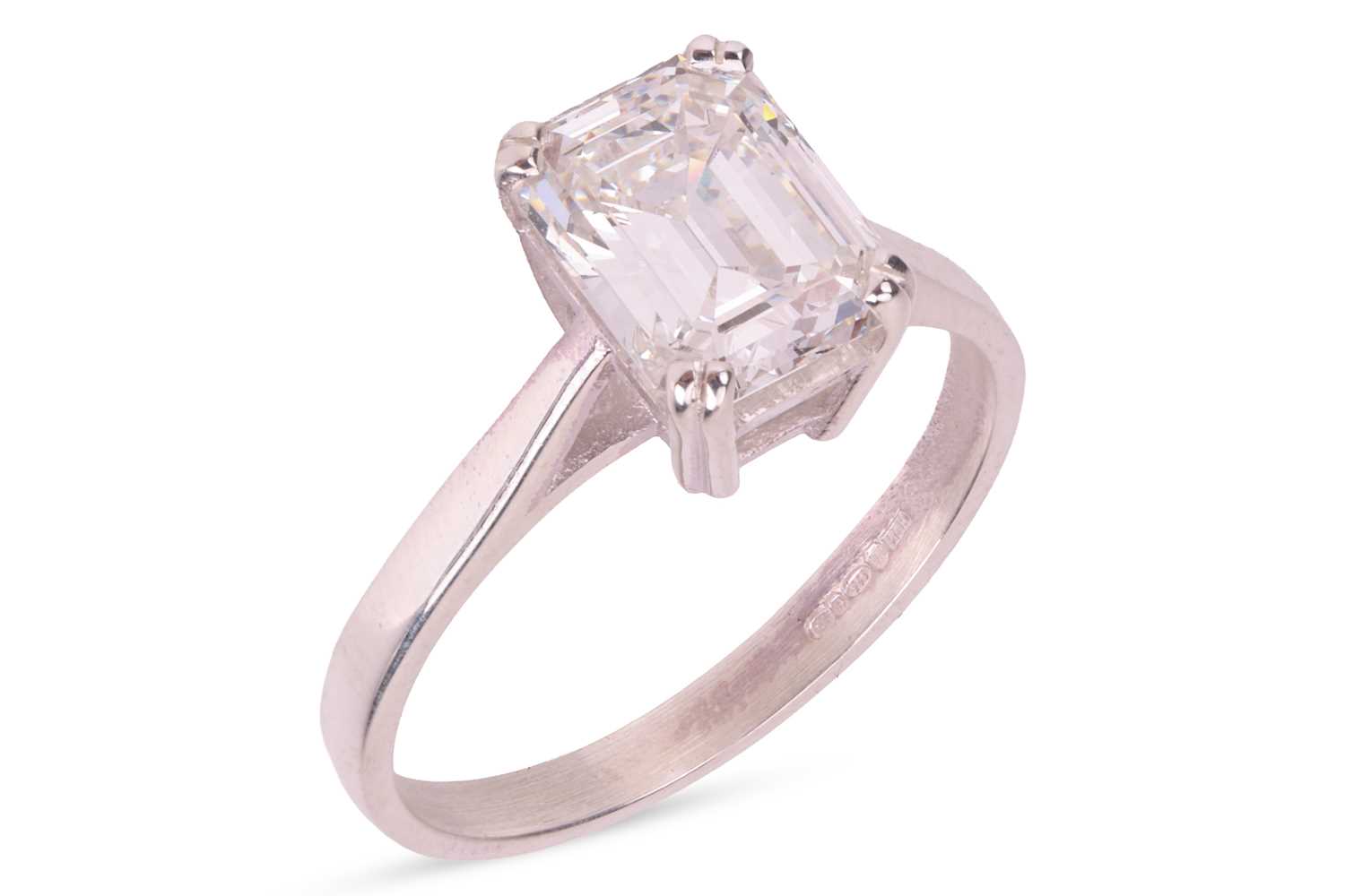 Lot An emerald-cut diamond solitaire ring,...