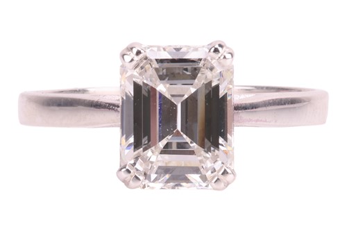 Lot An emerald-cut diamond solitaire ring,...