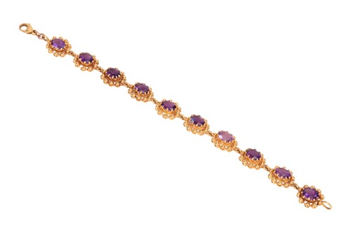 Lot 69 - An amethyst line bracelet, featuring ten oval...