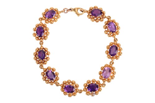 Lot 69 - An amethyst line bracelet, featuring ten oval...